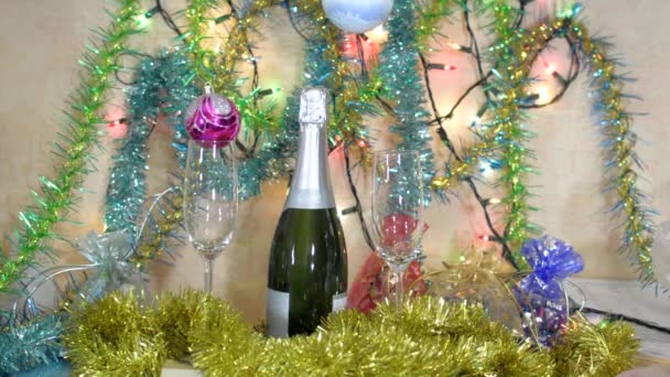 Karácsonyi dekoráció - egy üveg pezsgő, szemüveg, labdák és talmi — Stock videók