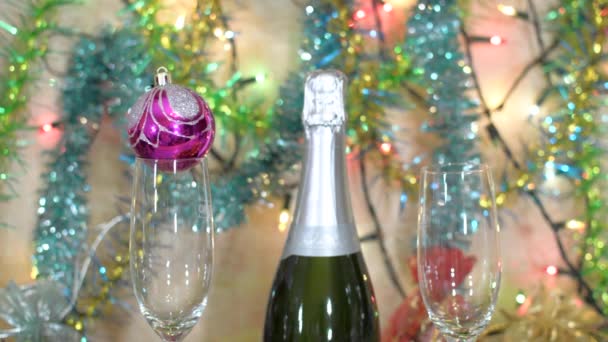 Decoración de Navidad - una botella de champán, copas, bolas y oropel — Vídeo de stock