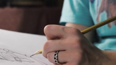 Bir kalem ile sanatçı bir kardan adam çizer