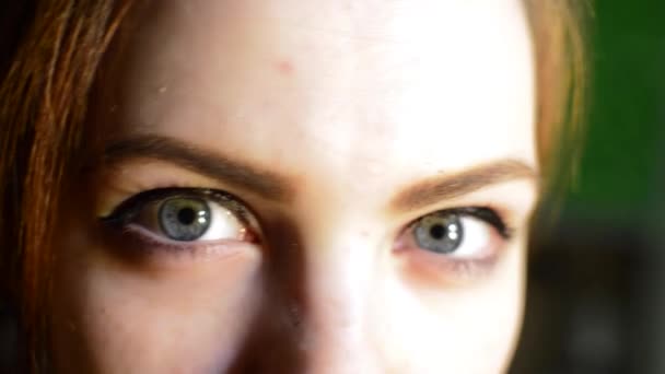 Девушка с красивыми зелеными глазами искажает кружки — стоковое видео