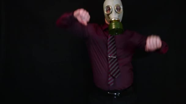 Businessman dancing in a gas mask on a black background — Stock Video