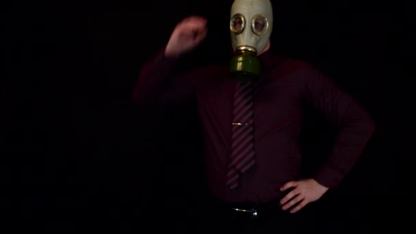 Hombre de negocios pensando y rascándose la cabeza con una máscara de gas sobre un fondo negro — Vídeos de Stock