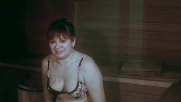 junge Frau sitzt im Badeanzug in einer heißen Sauna