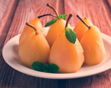 Beyaz tabakta nane ile haşlanmış armut