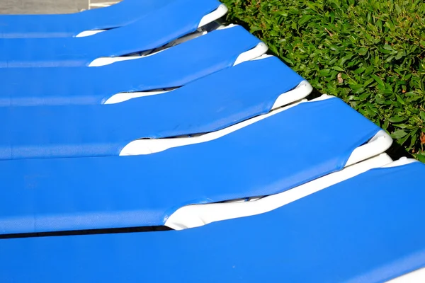 Cadeiras de praia azul e guarda-sol perto da piscina — Fotografia de Stock