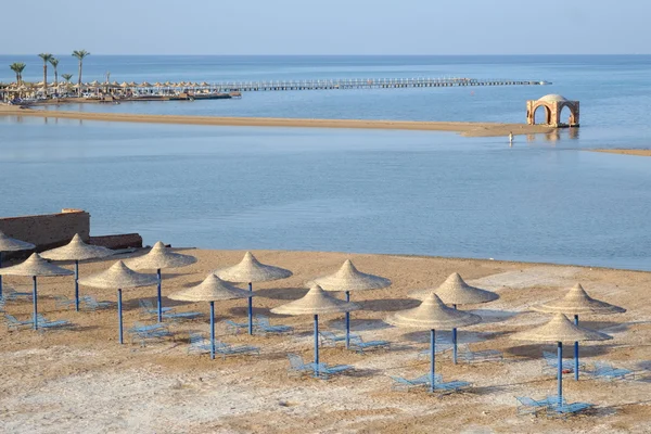 Blauwe strandstoelen en parasols op zand — Stockfoto