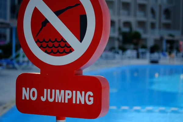 Red no jumping warning sign at the poolside Stock Photo
