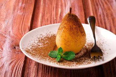 Kakao ve beyaz tabakta nane ile haşlanmış armut