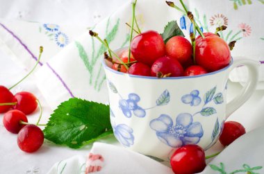 Tatlı olgun taze kiraz çilek Kupası'nda yeşil yaprakları ile