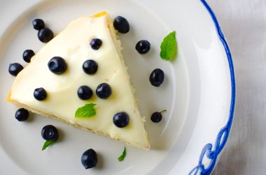 Ev yapımı kek krem, yaban mersini ve beyaz zemin üzerine nane