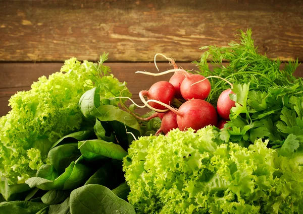 Grande grupo de vegetais orgânicos frescos, rabanete, espinafre, salada e verduras na velha mesa de madeira, close-up — Fotografia de Stock