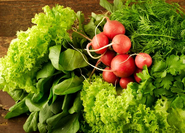 Grande grupo de vegetais orgânicos frescos, rabanete, espinafre, salada e verduras na velha mesa de madeira, close-up — Fotografia de Stock