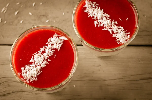 Sobremesa cremosa com molho de morango e flocos de coco em copos — Fotografia de Stock