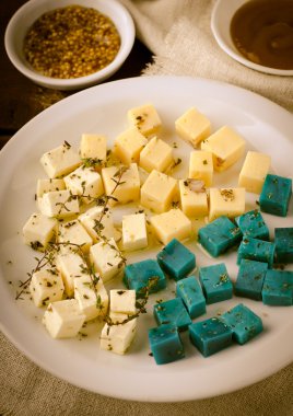 Peynir tabağı, Gouda, beyaz, mavi pesto peynir üzerinde otlar, zeytinyağı, nar ve hardal sos ile plaka beyaz