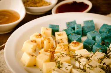 Peynir tabağı, Gouda, beyaz, mavi pesto peynir üzerinde otlar, zeytinyağı, nar ve hardal sos ile plaka beyaz