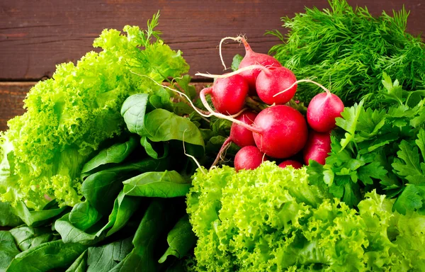 Grande grupo de vegetais orgânicos frescos, rabanete, espinafre, salada e verduras na velha mesa de madeira, close-up — Fotografia de Stock