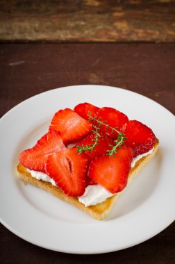 Krem peynir, çilek ve kekik ahşap masa üzerinde kızarmış ekmek