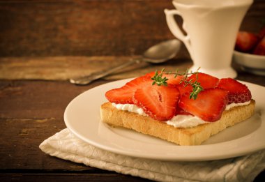 Krem peynir, çilek ve kekik ahşap masa üzerinde kızarmış ekmek