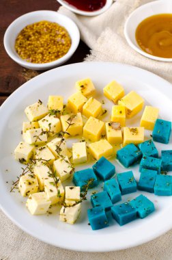 Peynir tabağı, Gouda, beyaz, mavi pesto peynir üzerinde otlar, zeytinyağı, nar ve hardal sos ile plaka beyaz