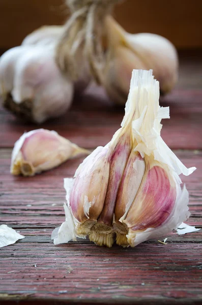 Oude biologische knoflook geheel en op de houten achtergrond teentjes — Stockfoto