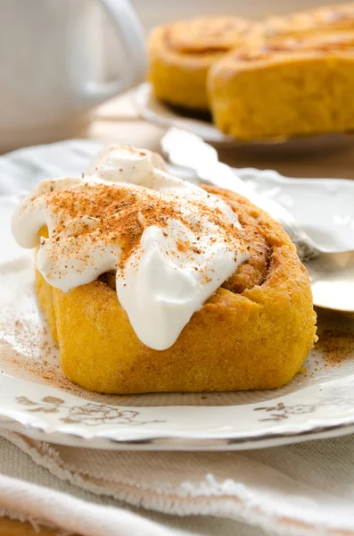 Pumpkin cinnamon rolls with spices and sweet cream Royalty Free Stock Photos