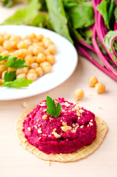 Hummus de beterraba com amendoim e salsa em bolachas finas — Fotografia de Stock