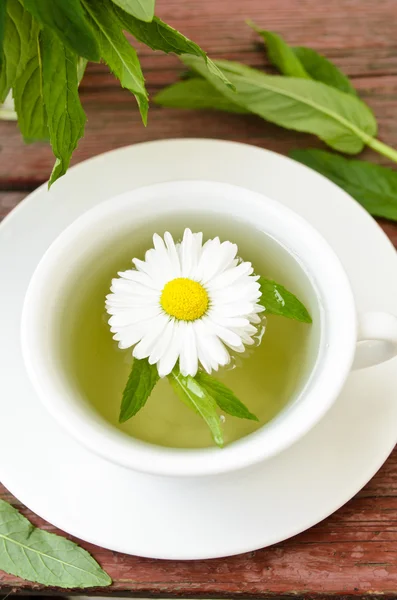 Taza de té de hierbas con manzanillas silvestres, menta y flores — Foto de Stock