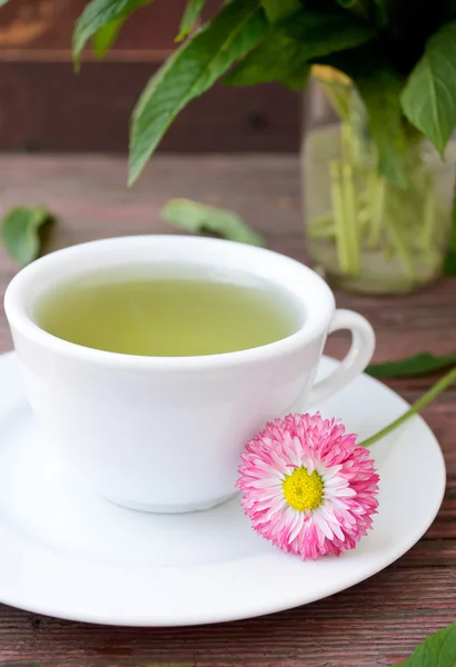 Taza de té de hierbas con manzanillas silvestres, menta y flores — Foto de Stock