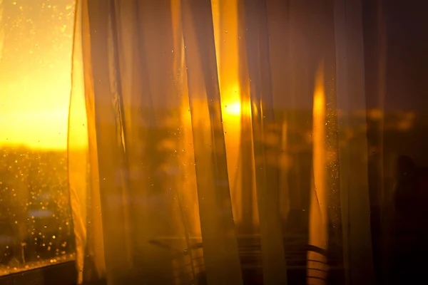 Vista o pôr do sol da varanda através de cortinas Imagem De Stock