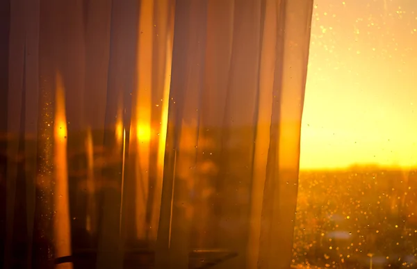 Vista o pôr do sol da varanda através de cortinas Imagem De Stock
