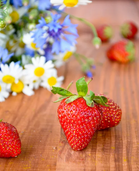 Prachtige wilde bloemen en verse aardbeien — Stockfoto