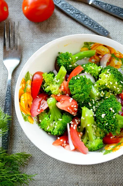 Salada verde com brócolis, tomate e sementes de gergelim — Fotografia de Stock