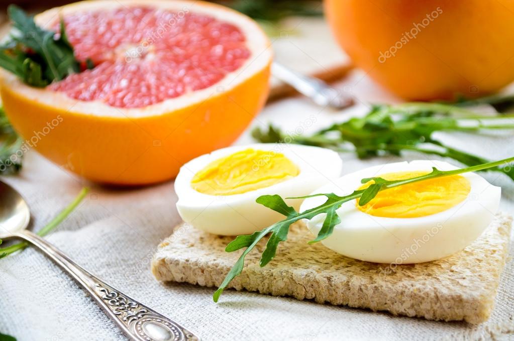 Healthy breakfast with eggs, grapefruit and fresh arugula