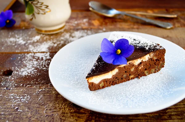 Pastel de chocolate casero con queso crema, nueces y flores — Foto de Stock