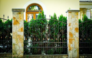 Sarı ev cephe çit ve yeşil ağaçları ile