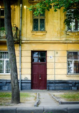 kırmızı kapı ile eski sarı ev cephe