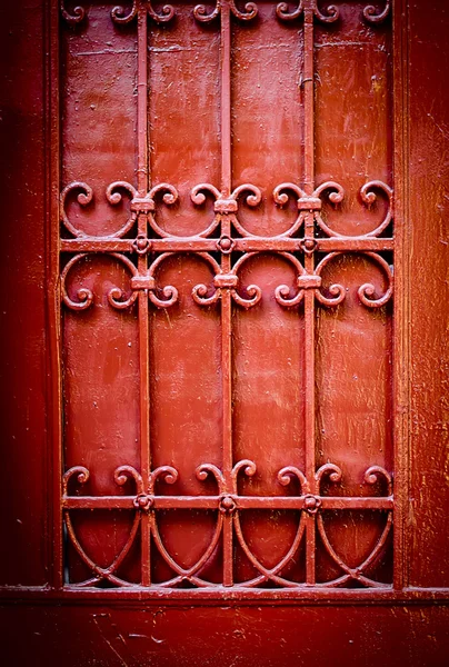 Detalhe da porta vermelha com ornamentos de ferro forjado — Fotografia de Stock