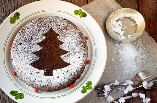 Hausgemachter Schokoladen-Weihnachtskuchen mit Zuckerpulver bestreut — Stockfoto