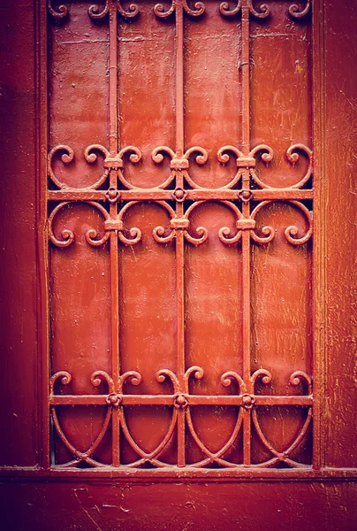 Detalhe da porta vermelha com ornamentos de ferro forjado — Fotografia de Stock