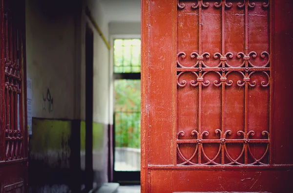 Detalhe da porta vermelha com ornamentos de ferro forjado — Fotografia de Stock