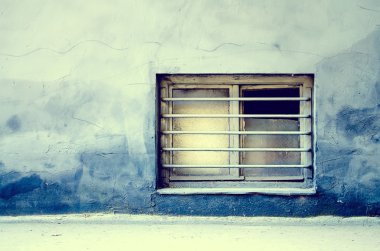 Kirli eski pencere çubukları üzerinde eski bir bina ile