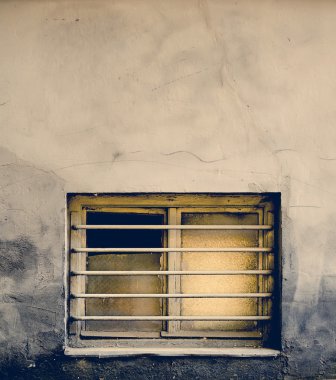 Kirli eski pencere çubukları üzerinde eski bir bina ile