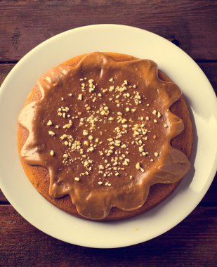 Karamel ve ahşap masa üzerinde fıstık ile kabak pasta