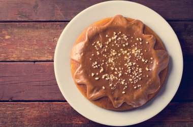 Karamel ve ahşap masa üzerinde fıstık ile kabak pasta