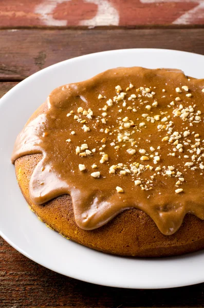 Gâteau à la citrouille au caramel et cacahuètes sur table en bois — Photo