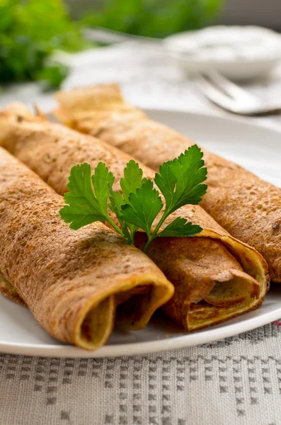 Rolos de panqueca com cogumelos, iogurte e salsa — Fotografia de Stock