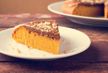 Karamel ve ahşap masa üzerinde fıstık ile kabak pasta