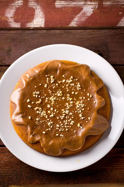 Gâteau à la citrouille au caramel et cacahuètes sur table en bois — Photo