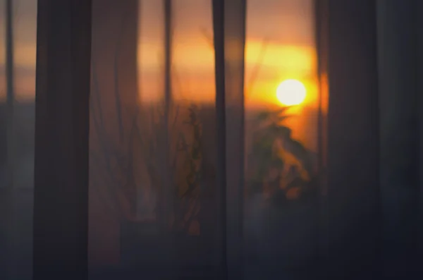 Vista o pôr do sol da varanda através de cortinas — Fotografia de Stock