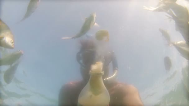 Homem Alimentando peixes de uma garrafa — Vídeo de Stock